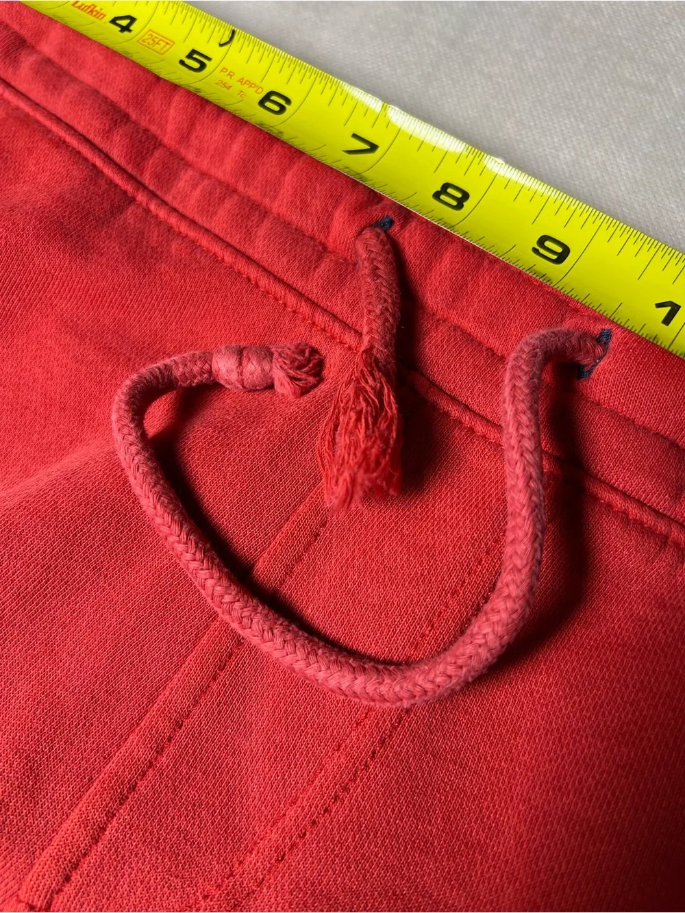 Hollister Co. red sweatpants with white vertical text reading 'HOLLISTER'